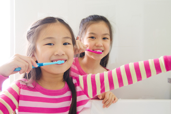 Two twin practicing good children's dental health.